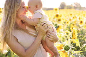 Mother and child in field with sunflowers