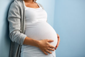 Pregnant woman feeling her stomach